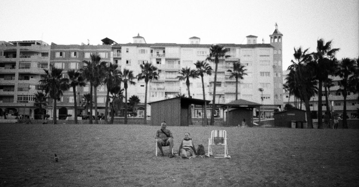 Dos personas conversando frente a frente con grabadora sobre la mesa